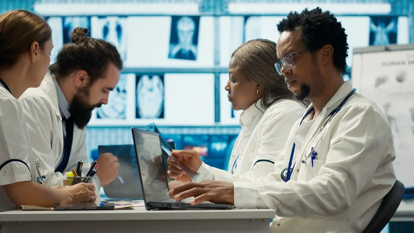 Médicos examinan los resultados de radiografías en una reunión con el personal.